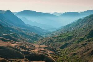 cênico alvorecer montanha panorama. montanha textura, montanha terreno. vívido pôr do sol ou nascer do sol cenário com baixo nuvens dentro montanha vale dentro suave cor. foto