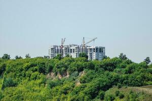 construção do uma casa dentro a ecológico verde área. moderno casa é ser construído em uma verde colina. foto