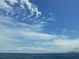 a azul céu com branco nuvens acima a grande oceano foto