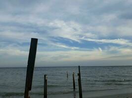 a céu acima a de praia com a sombra do uma de madeira silhueta em pé direito foto