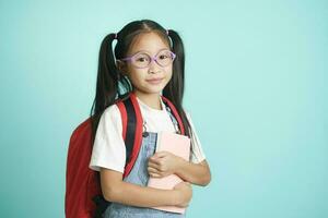 criança alunos menina sorridente segurando livro, indo para escola. foto