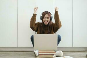 jovem mulheres estude dentro frente do a computador portátil computador às lar. foto