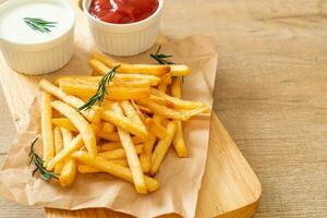 batatas fritas com creme de leite e ketchup foto