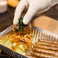chef colocando verduras nas salsichas alemãs foto