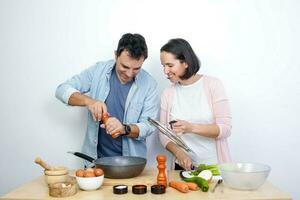 jovem casal cozinhando foto