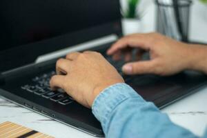 do homem mão sentado em computador portátil foto