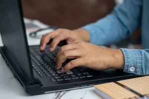 do homem mão sentado em computador portátil foto