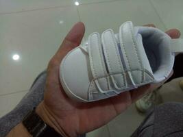 foto do uma fofa pequeno branco bebê sapato com triplo adesivo