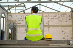 Engenharia homem com segurança capacete localização sobre construção local fundo analisando sobre projeto progresso foto