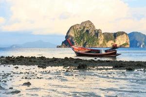 barco nativo na praia e nascer do sol pela manhã em trang tailândia foto