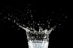 água respingo dentro uma vidro. água respingo isolado em Preto. foto