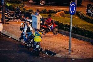 ho chi minh cidade, Vietnã - abril 14, 2023 tráfego geléia às morreu bem phu rotunda com Está quatro caras relógio torre uma símbolo do ho chi minh cidade. luz trilha a partir de carros. foto