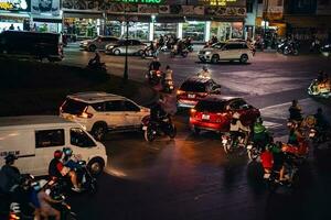 ho chi minh cidade, Vietnã - abril 14, 2023 tráfego geléia às morreu bem phu rotunda com Está quatro caras relógio torre uma símbolo do ho chi minh cidade. luz trilha a partir de carros. foto