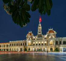 ho chi minh, viet nam - 10 abril 2023 Saigon cidade salão, Vincom Centro torres, colorida rua tráfego e tropical plantas contra a surpreendente noite. Saigon centro da cidade com Está famoso pontos de referência. foto