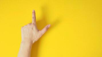masculino modelo é ponto a dedo acima mão placa com costas mão em amarelo fundo. foto