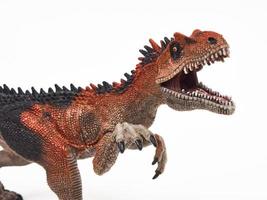 brinquedo de borracha de dinossauro saurophaganax isolado no branco foto