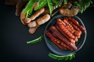 Tamarindo descasca dentro prato tropical frutas verão, Tamarindo doce para Comida fruta maduro tamarindos em prato e branco fundo - topo Visão foto