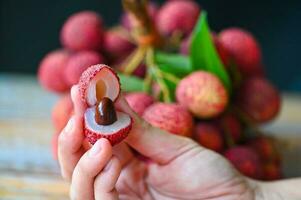 fresco maduro lichia fruta tropical fruta descascado lichias fatia dentro tailândia, lichias em mão foto