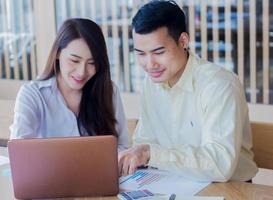 empresários asiáticos estão ensinando empregos para novas gerações no conceito de trabalho em equipe no escritório foto