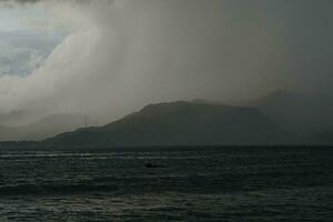 tempestade sobre a mar com montanhas dentro a fundo foto