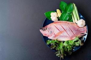 vista superior de peixe fresco e vegetais em pratos de cerâmica preparados para cozinhar com espaço de cópia foto