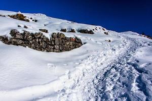 caminho entre neve e pedras foto