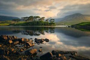 lindo nascer do sol panorama cenário do doze pinheiros ilha às Derryclare lago dentro connemara nacional parque, município galway, Irlanda foto