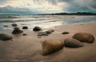 dramático nublado pôr do sol costeiro panorama cenário do arenoso Silverstrand de praia dentro município galway, Irlanda foto