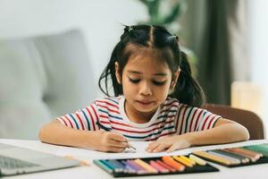seletivo foco do fofa ásia criança desenhando com cor lápis às casa foto