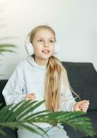 fofa pequeno menina ouvindo para música dentro fones de ouvido foto