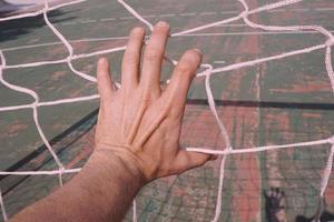 mão agarrando uma rede de corda foto