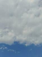 nuvens brancas no céu azul. lindo fundo azul brilhante. claro nublado, bom tempo. nuvens encaracoladas em um dia ensolarado. foto