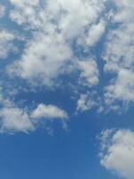 nuvens brancas no céu azul. lindo fundo azul brilhante. claro nublado, bom tempo. nuvens encaracoladas em um dia ensolarado. foto