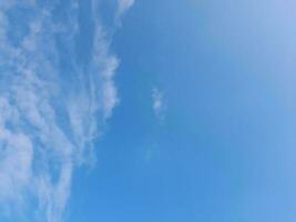 nuvens brancas no céu azul. lindo fundo azul brilhante. claro nublado, bom tempo. nuvens encaracoladas em um dia ensolarado. foto