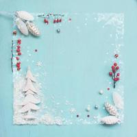 Enfeites de pinha branca e bagas vermelhas sobre fundo azul, fundo de Natal com espaço de cópia