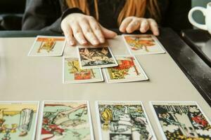 tver, Rússia - fevereiro 11, 2023. tarot cartões, tarot cartão adivinhação, esotérico fundo. uma mulher faz uma disposição em a cartões às a mesa. adivinhação, previsões em tarot cartões. foto