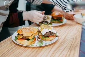 hambúrgueres com carne e legumes. fechar acima. delicioso hambúrgueres dentro uma cozinhando aula. hamburguer com oxicoco molho e hamburguer com cebola molho. foto