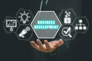 o negócio desenvolvimento conceito, o negócio pessoa mão segurando o negócio desenvolvimento ícone em virtual tela. foto
