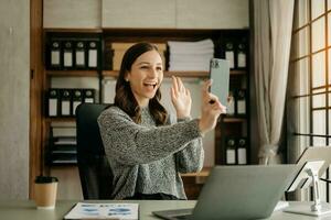 conceito de mulher trabalhadora uma gerente feminina participando de videoconferência e segurando tablet, smartphone e xícara de café no escritório foto