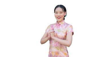 cheongsam vestir dentro chinês Novo ano tema enquanto ela mostra dela mão Como chinês cumprimento com isolado em branco fundo. foto