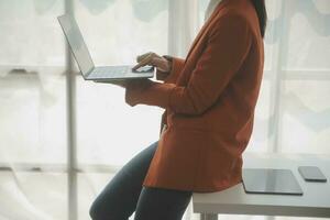 close-up mulher de negócios usando calculadora e laptop para fazer finanças matemáticas na mesa de madeira, impostos, contabilidade, estatística e conceito de pesquisa analítica foto