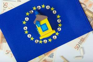 europeu bandeira, borracha casa e europeu moeda. topo Visão foto