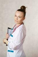 jovem fêmea médico vestido dentro uma branco médico uniforme foto