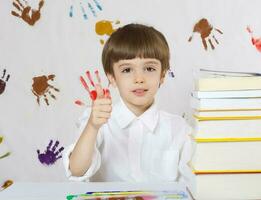 Garoto do Sete anos velho com livros. costas para escola foto