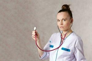 jovem fêmea médico vestido dentro uma branco médico uniforme foto