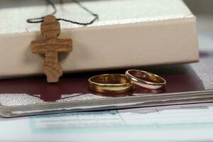 casamento argolas fechar para Bíblia com de madeira Cruz. foto