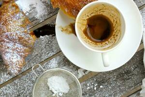 uma sujo copo depois de café em uma de madeira superfície. foto