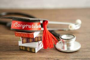 graduação chapéu em livro e estetoscópio com cópia de espaço, médico Aprendendo remédio universidade Educação conceito. foto