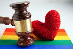martelo para juiz advogado com bandeira do arco-íris do coração, símbolo do mês do orgulho lgbt. foto