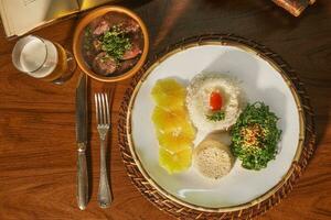 lindo prato do feijoada com cerveja. dentro a fundo velho livros foto